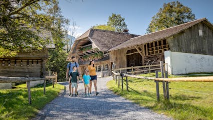 Familienspaziergang vor dem Bauernhaus aus Tentlingen FR (511) im Freilichtmuseum Ballenberg.