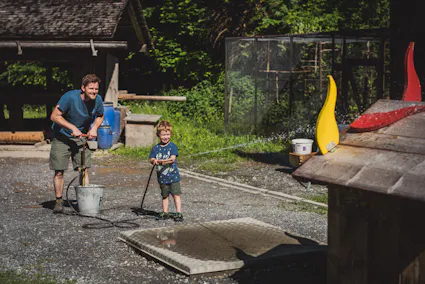 Im Freilichtmuseum Ballenberg gibt es Stationen zum Mitmachen und Ausprobieren. So auch hier: Bei der Station «Wasser marsch!» kann mit einer Handspritze die Holzflammen gelöscht werden.
