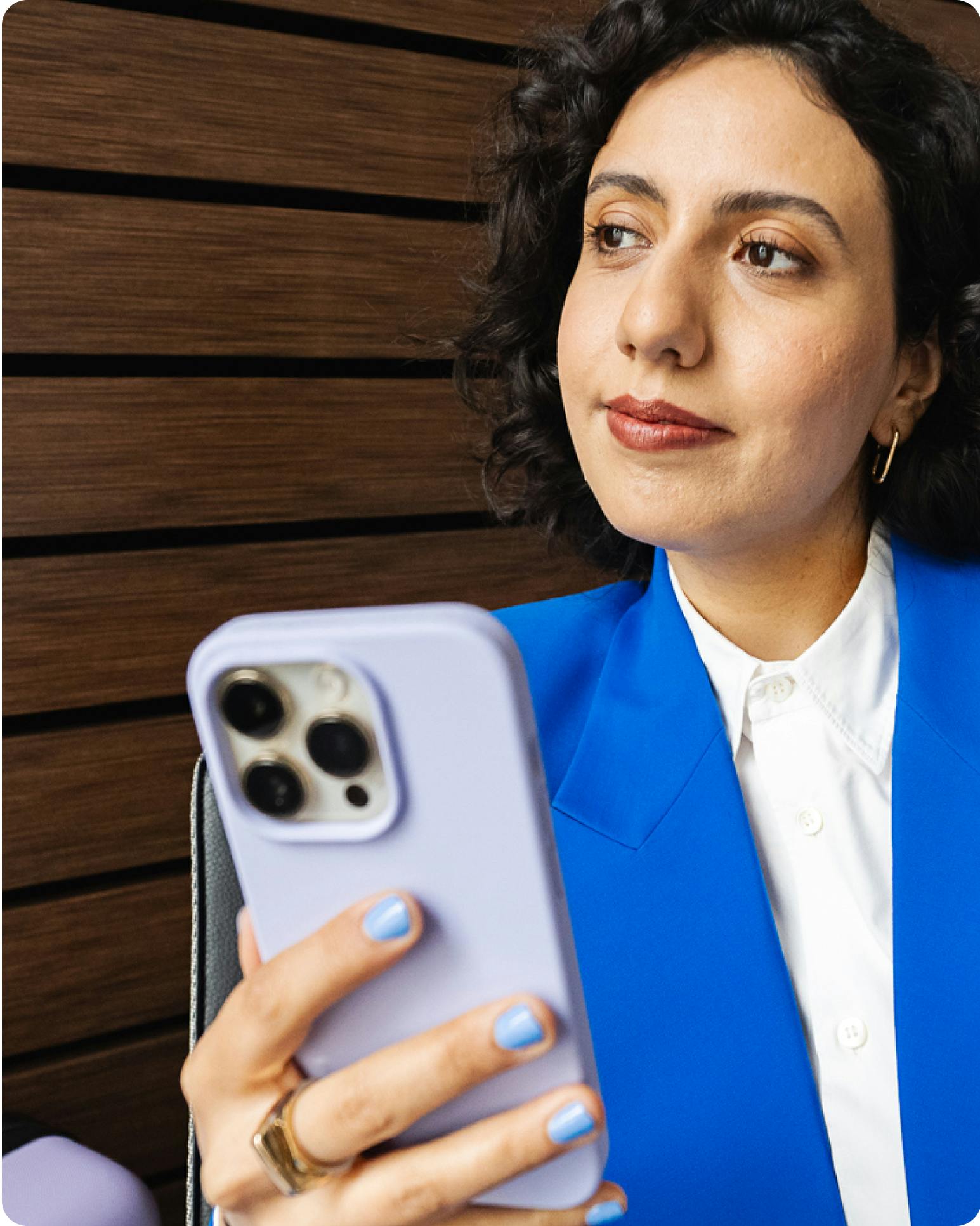 Eine Frau wartet mit ihrem Handy am Flughafen.