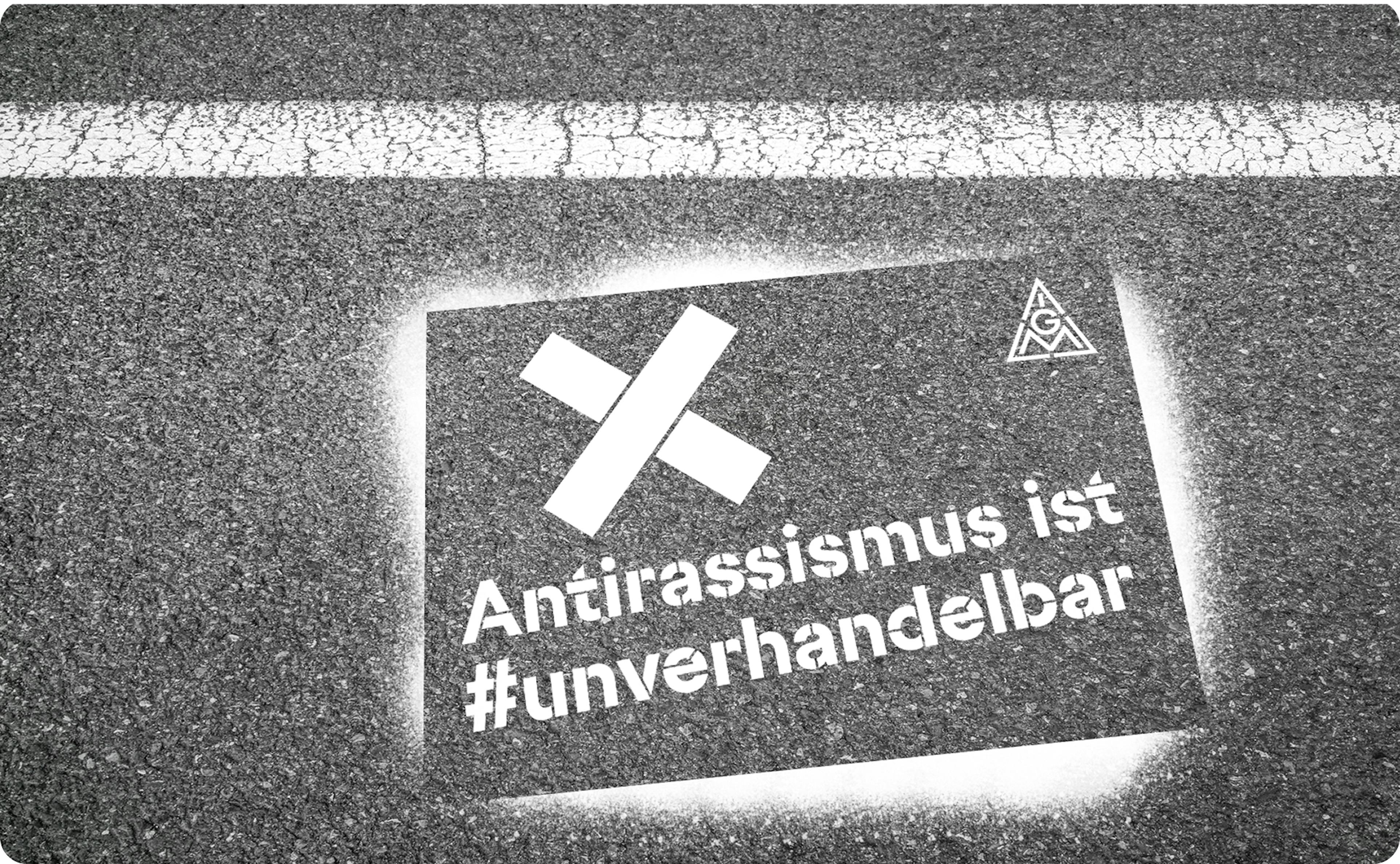 Bild von auf die Straße aufgesprühtem Schriftzug "Antirassismus ist #unverhandelbar", darüber ein Kreuz und das IG-Metall-Logo.