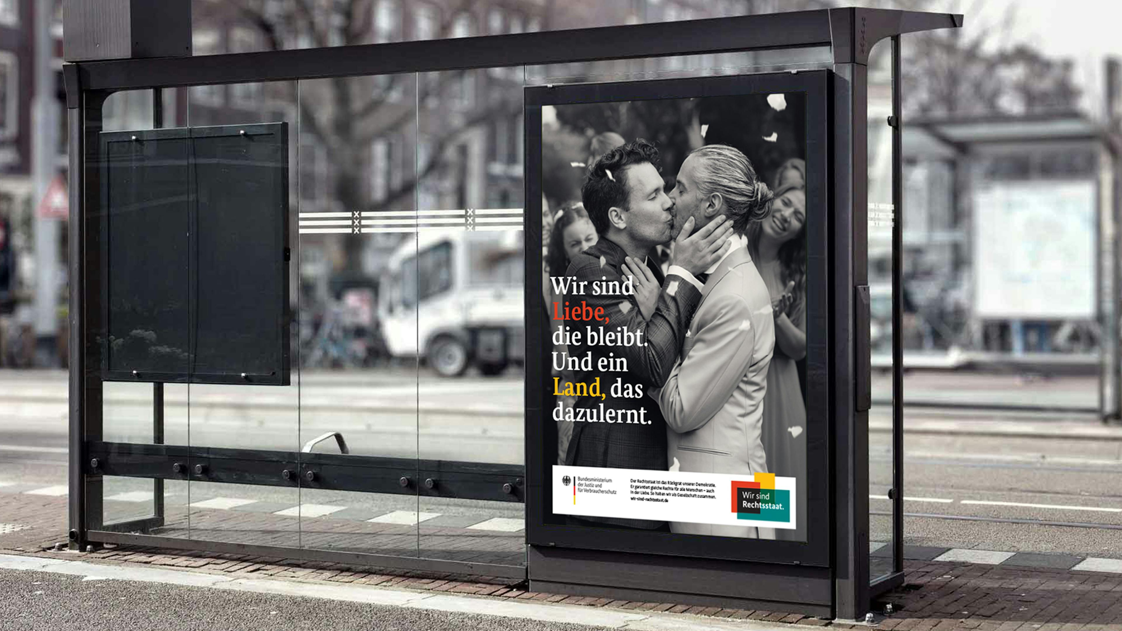 Plakat von zwei Männern, die sich auf ihrer Hochzeit küssen. Schriftzug "Wir sind Liebe, die bleibt. Und ein Land, das dazulernt."
