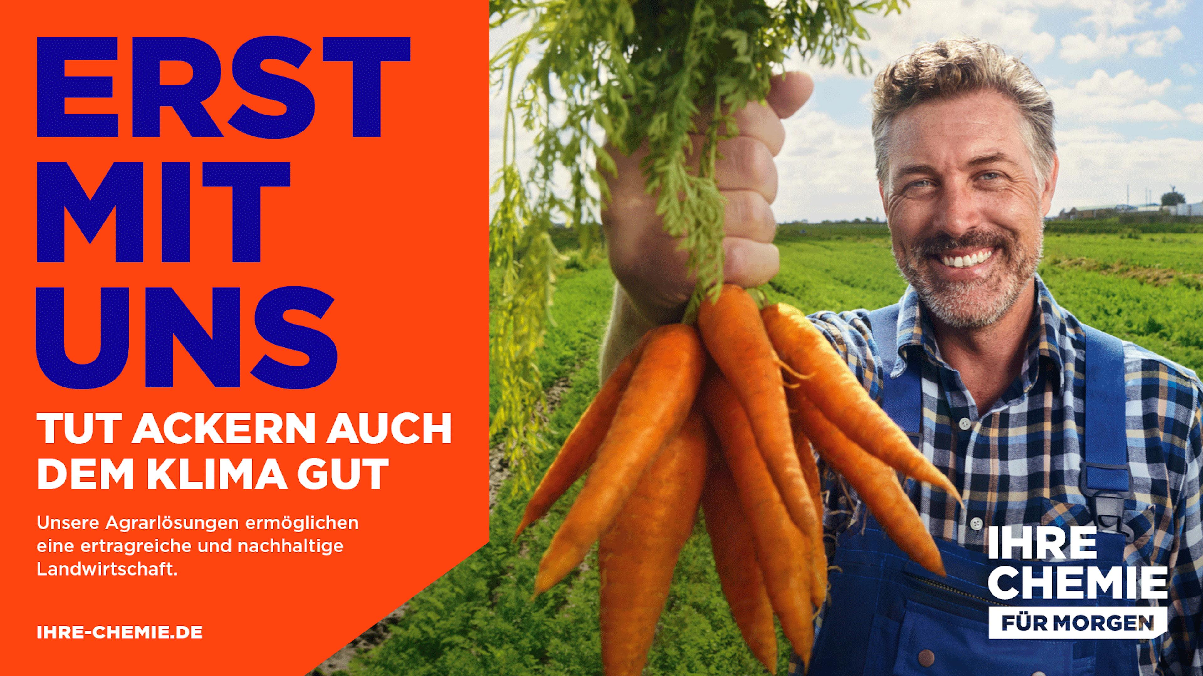 Kampagnenmotiv "Erst mit uns tut Ackern auch dem Klima gut" mit einem Landwirt, der Karotten hochhält.