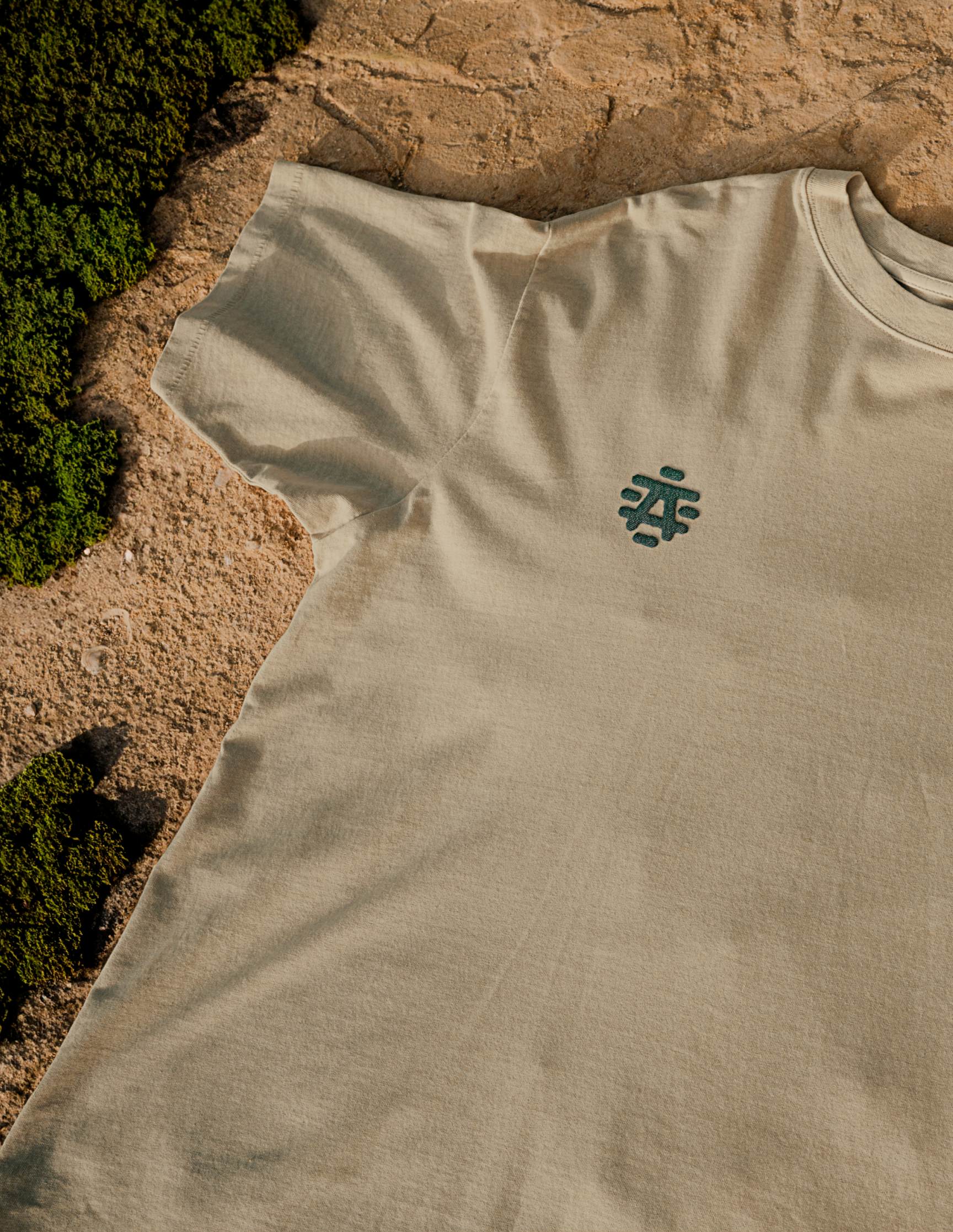 beige t-shirt on rock background with grass