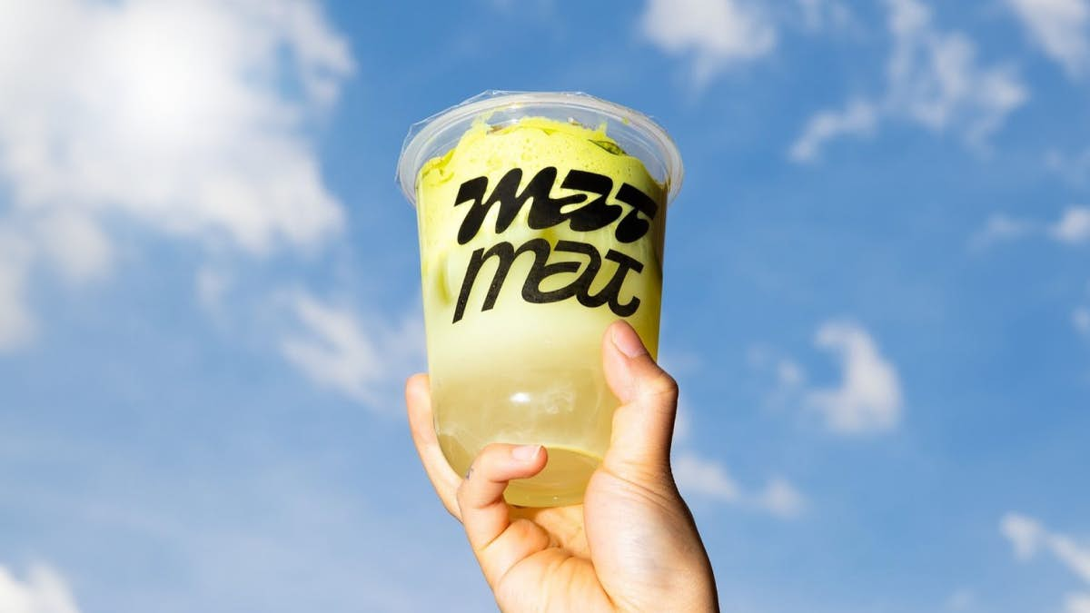 boba tea cup in a hand against the sky