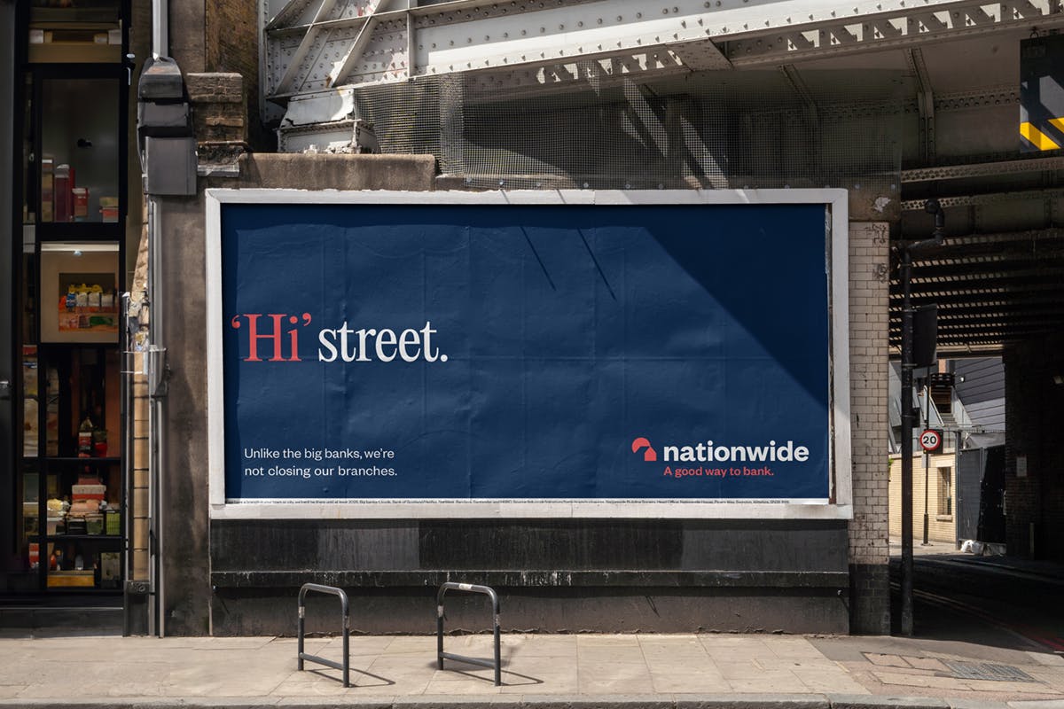 Billboard on city street reads: 'Hi' street. Unlike the big banks, we're not closing our branches. Nationwide, a good way to bank.
