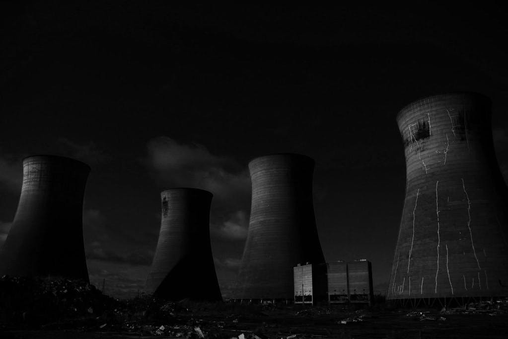 Thorpe Marsh Power Station. Four decaying cooling stacks rise out of the dark gloom at an abandoned coal power plant in Yorkshire.