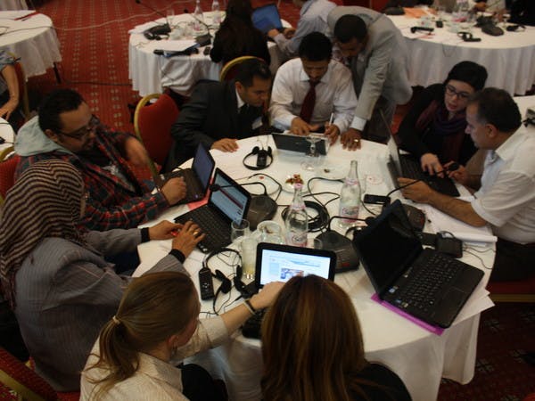 A group of people work at a round table