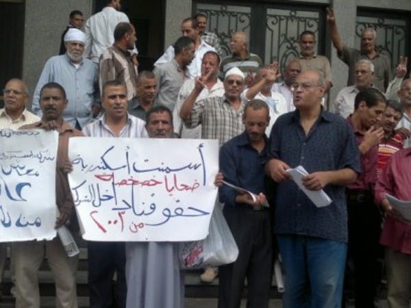 Protesters hold signs written in Arabic