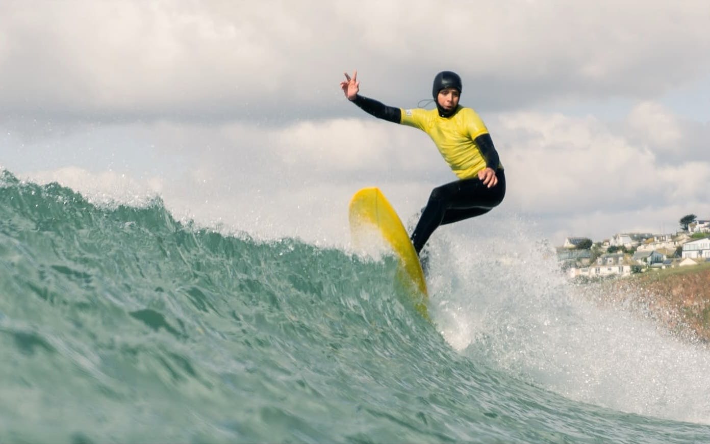 Bantham surfer in a yellow outfit on the crest of a wave