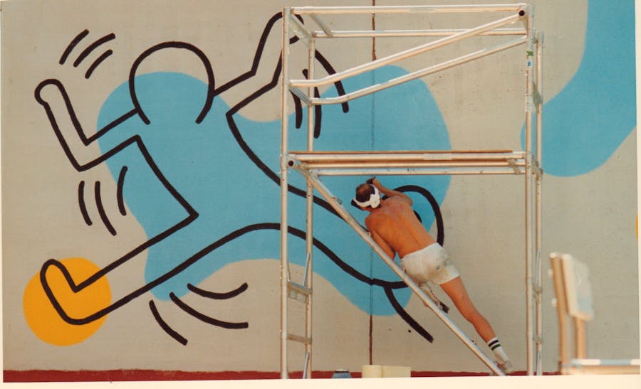 Keith Haring works on a mural on 50th Street, Manhattan, New York, August 20, 1987. Photo: Getty Images
