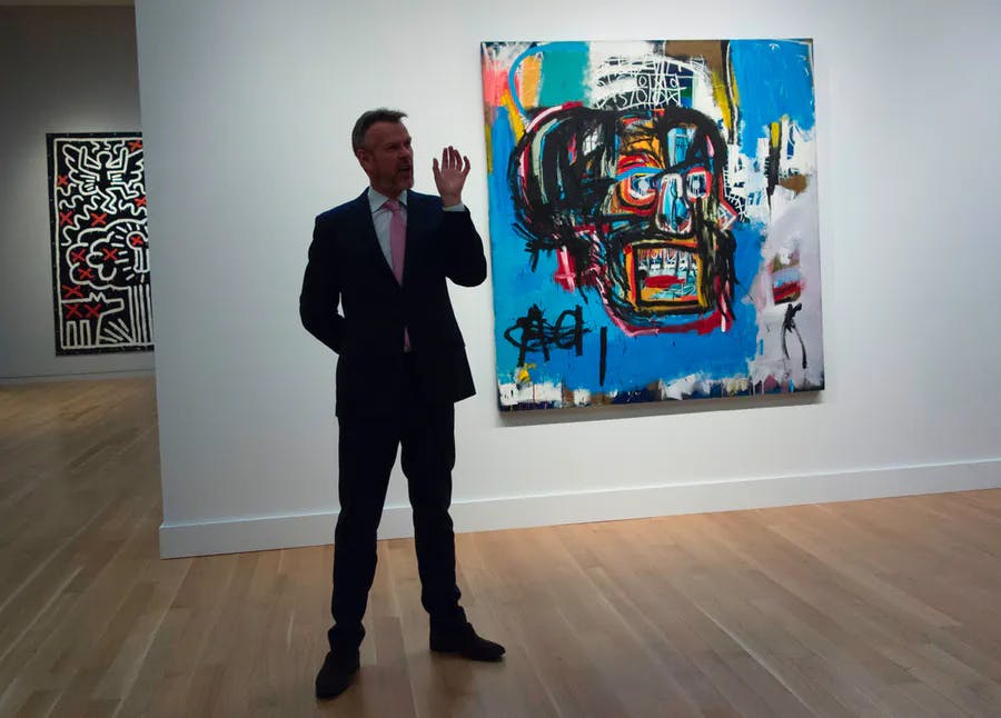 Un responsable de Sotheby's parle de l'œuvre « Untitled » de Jean-Michel Basquiat lors d'une avant-première médiatique le 5 mai 2017 chez Sotheby's New York. L'œuvre est l'une des créations mises aux enchères lors de la vente du soir d'art impressionniste et moderne le 16 mai 2017 à New York. Photo © DON EMMERT/AFP via Getty Images