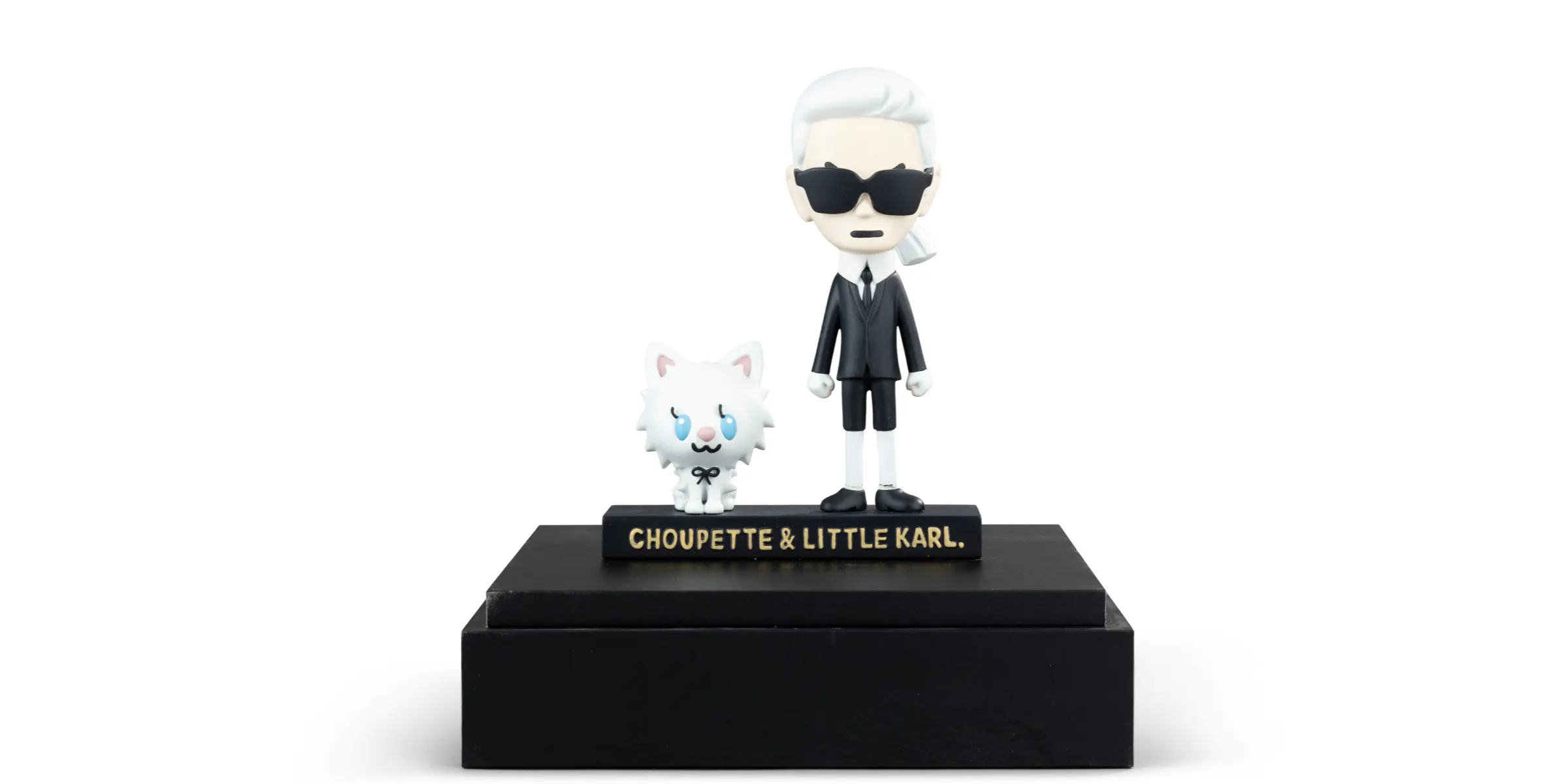 Karl Lagerfeld und Choupette, Figuren von Karl Lagerfeld und Choupette unter Plexiglas. Foto © Sotheby's