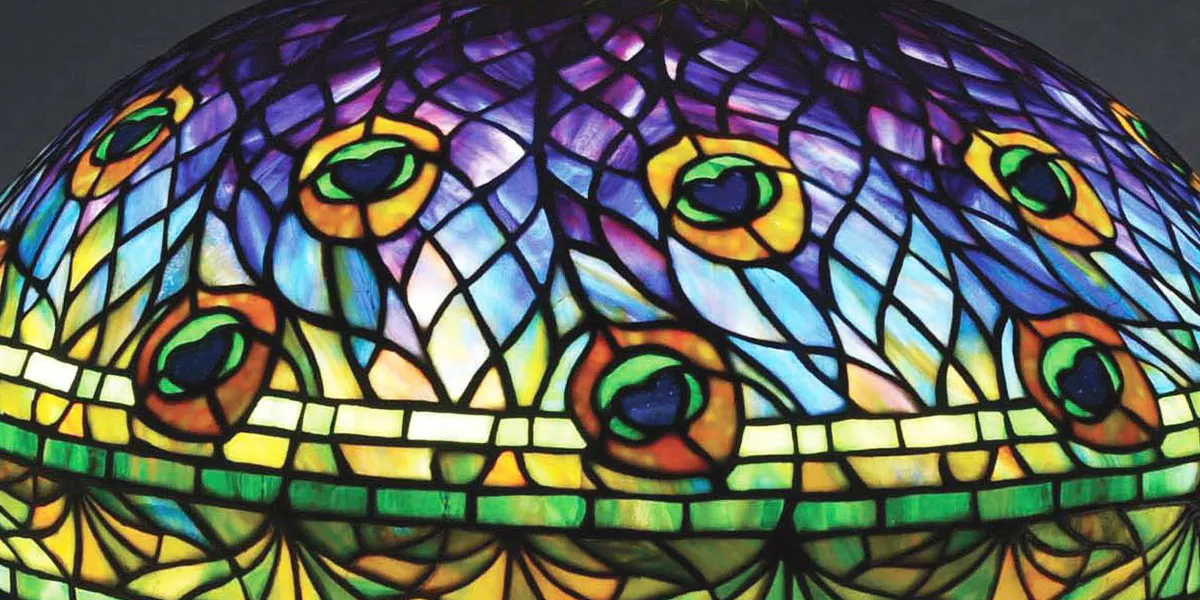 Lampada da tavolo in vetro piombato "Peacock" di Tiffany Studios su rara base "Peacock" abbinata. Uno dei modelli di vetro più amati e iconici di Tiffany, con un motivo di piume di pavone con "occhi" accattivanti. Paralume e base firmati. Venduta al di sopra della stima massima a 307.500 dollari. Immagine per gentile concessione di Morphy Auctions