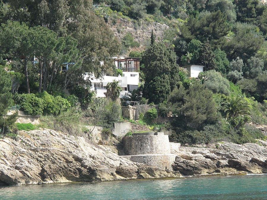 Dietro l'albero si trova la villa E-1027 sulla costa di Roquebrune-Cap-Martin, Alpes-Maritimes, Francia. Immagine di pubblico dominio