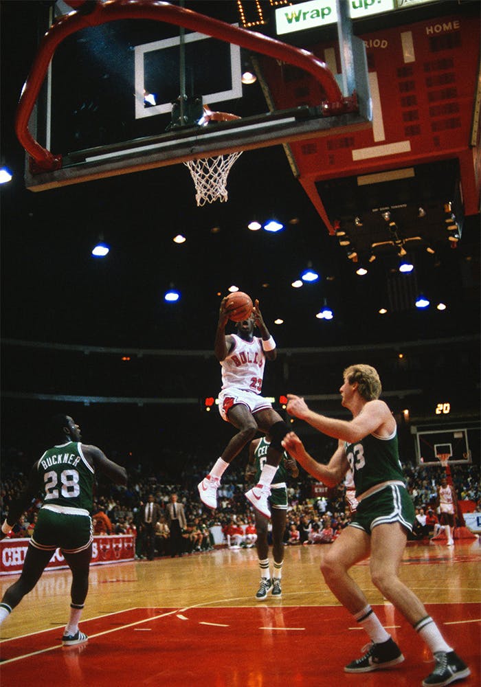 Bulls vs Celtics, Nike vs Converse, 1985. Michael Jordan flyger över en annan legend – Larry Bird. Notera Quinn Buckners skor. Ser ut som att veteranen under sitt sista år i Boston spelade i Adidas låga modell Gazelle. Foto: Getty Images 