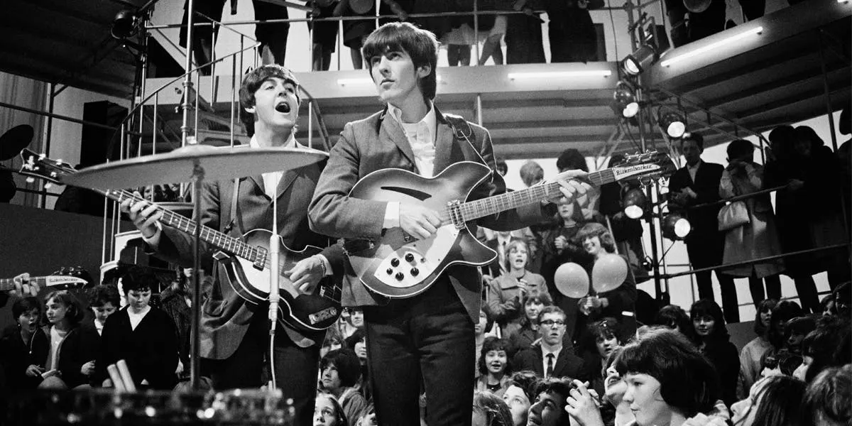 Paul McCartney (izquierda) y George Harrison (1943-2001), Los Beatles, ensayo para un programa, " Round The Beatles " ,en los estudios de  TV de Wembley, Londres, 27 abril de 1964 [detalle]. Imagen © Jim Gray / Keystone / Hulton Archive via Getty Images