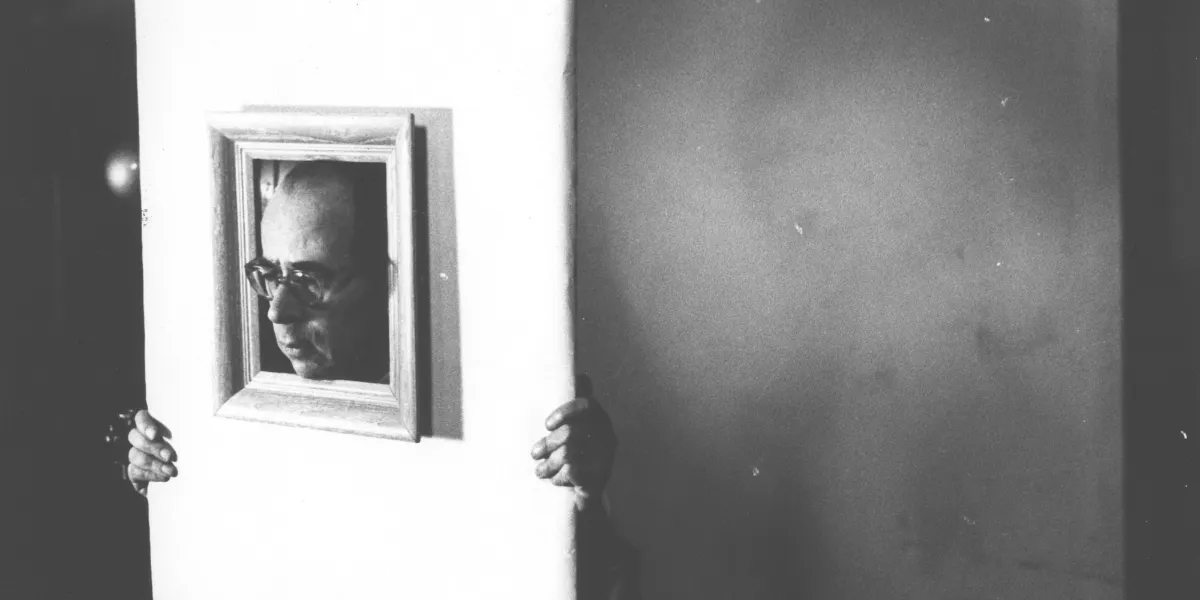 La testa del fotografo Philippe Halsman (1906 - 1979) in una cornice, un oggetto da studio e una pila di libri con sopra la Mosca di Henri Cartier-Bresson, circa 1950. (Foto di Weegee(Arthur Fellig)/ Centro Internazionale di Fotografia/ Getty Images) (dettaglio)