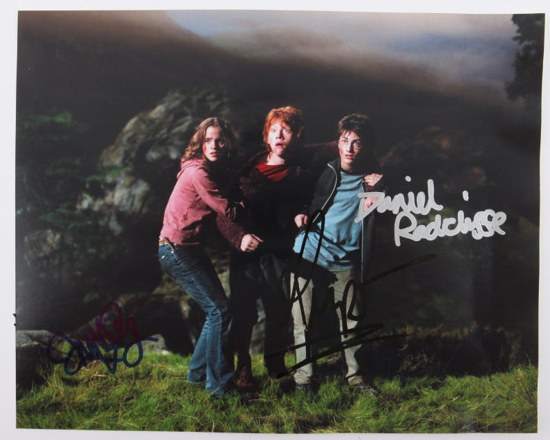 Colour photograph signed by Daniel Radcliffe, Emma Watson and Rupert Grint, 10 x 8 inches. Photo © Ewbank's