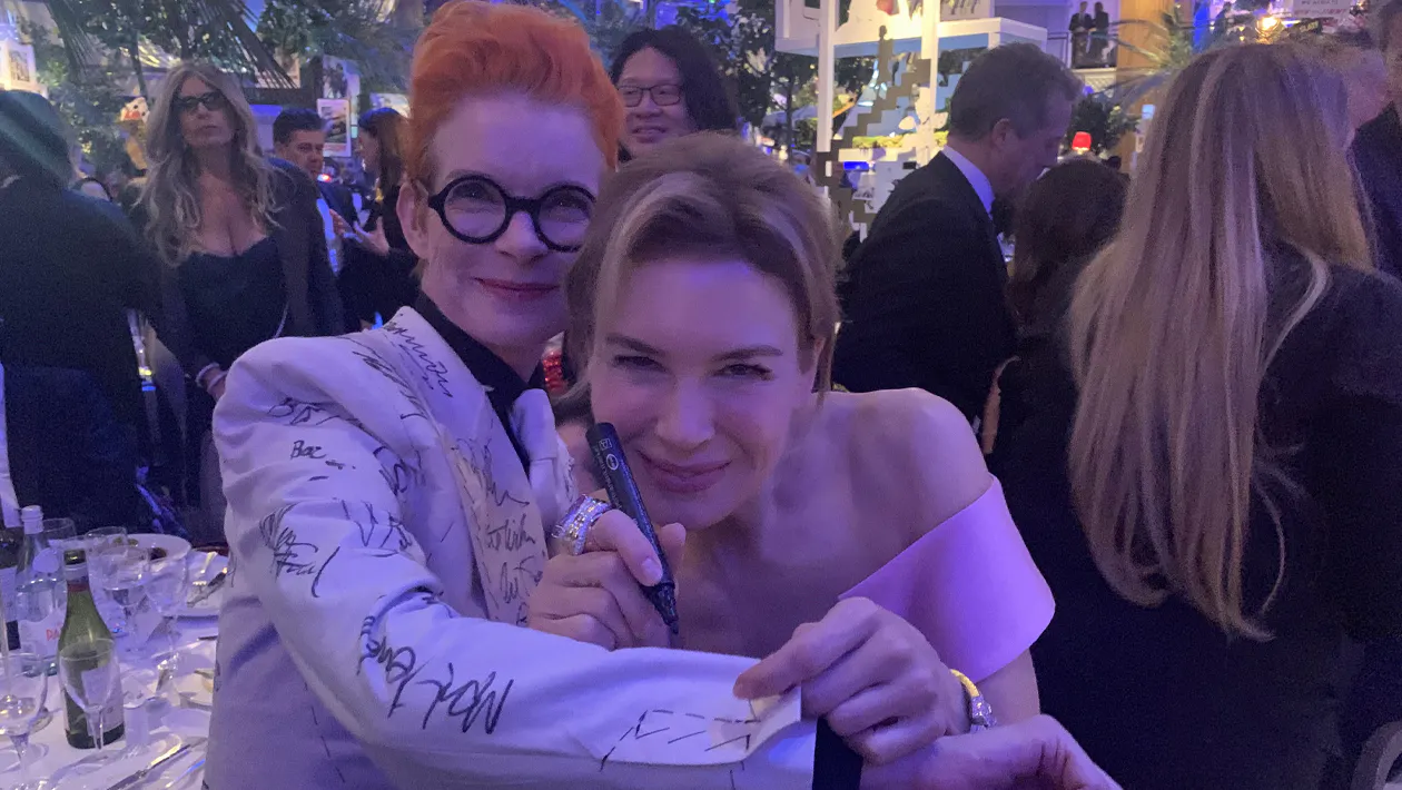 Sandy Powell with actor Renee Zellweger signing her suit. The suit is to be auction to help save Derek Jarman’s Prospect Cottage. Photo © Sandy Powell/Instagram