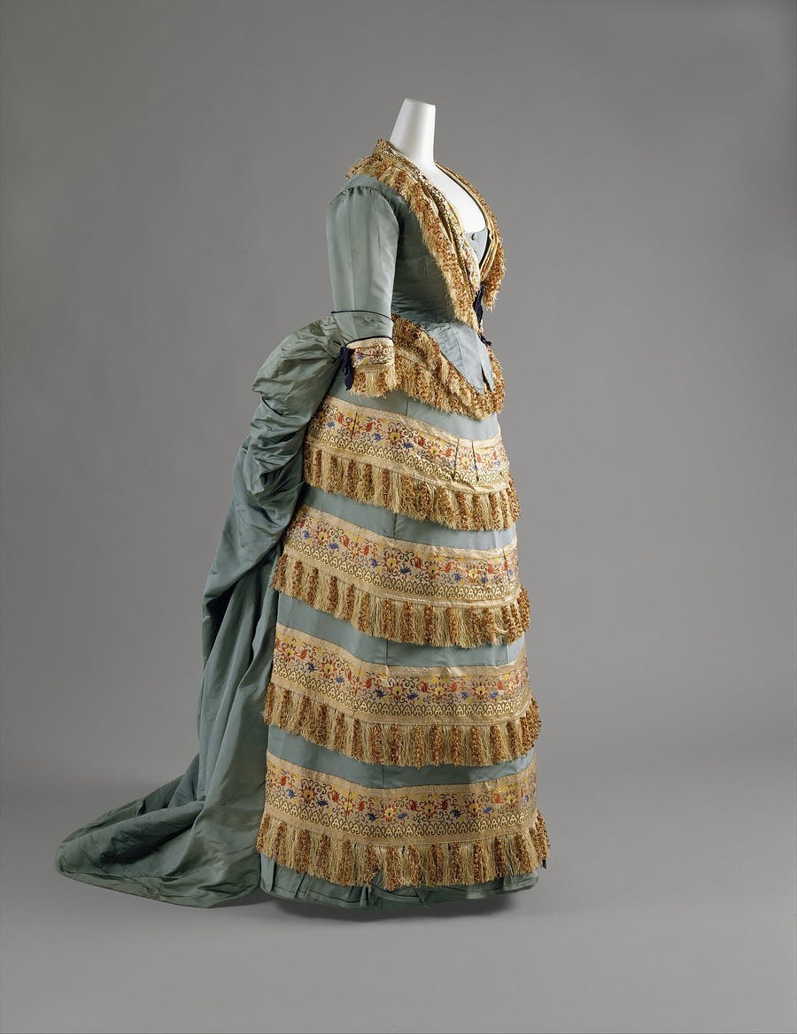 Evening dress in silk from House of Worth around 1872, designed by Charles Frederick Worth. Public domain image via Metropolitan Museum of Art, Gift of Mrs. Philip K. Rhinelander, 1946.