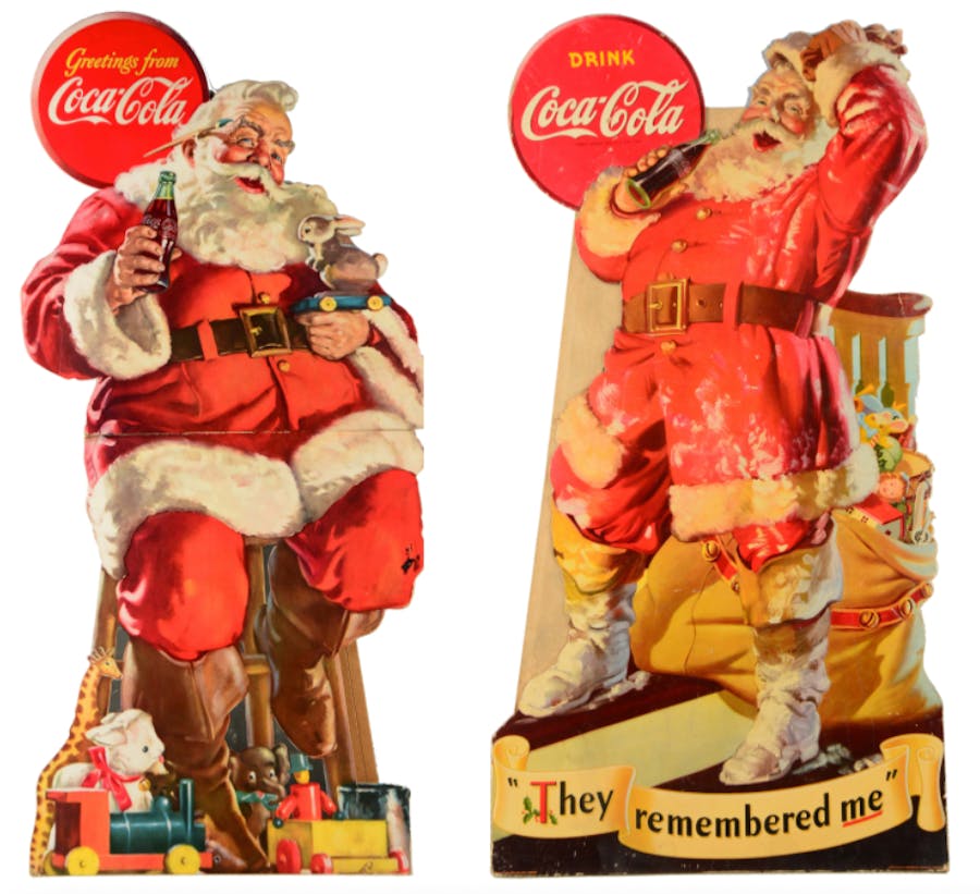A sinistra: grande insegna pubblicitaria di Babbo Natale fustellato della Coca-Cola | A destra: grande insegna pubblicitaria fustellata della Coca-Cola Santa del 1942. Foto © Morphy Auctions