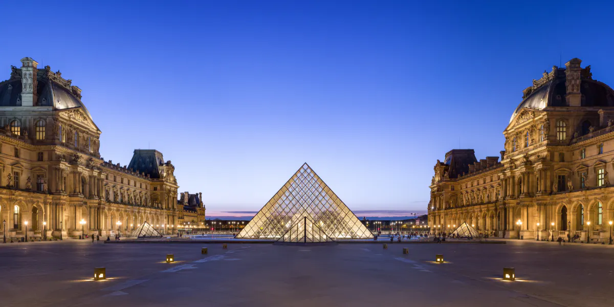 Looking west at the Louvre Museum's Napoleon Courtyard, at dusk. Photo by Behn Lieu Song via Wikimedia Commons, Licence CC BY-SA 4.0