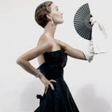 Model in profile wearing black satin Christian Dior evening dress, one long white glove holding fan (detail). (Photo by Erwin Blumenfeld/Condé Nast via Getty Images) 