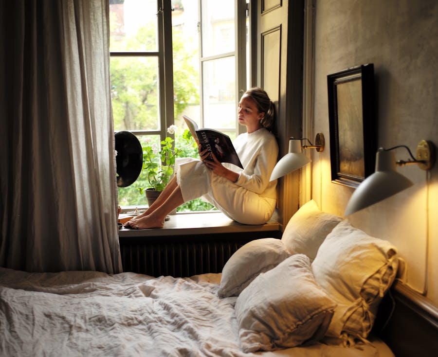 Annika curled up in the bedroom's window facing the open and leafy courtyard. Photo © Pontus Wallberg