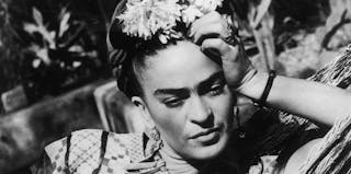 Frida Kahlo, i en traditionell klänning, sittandes i en hängmatta. Foto © Hulton Archive / Getty Images (detalj)