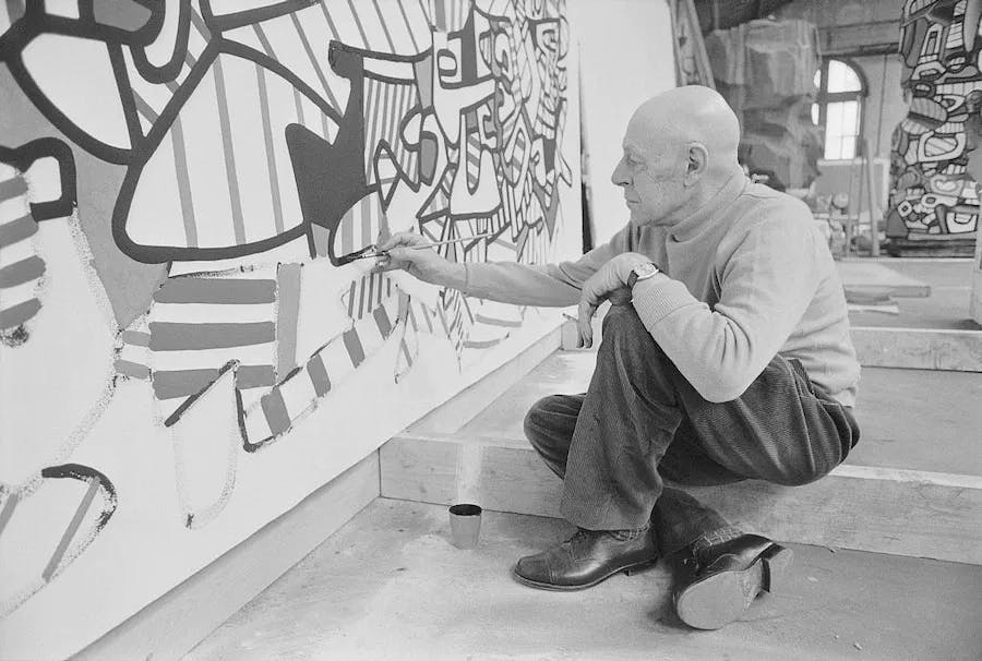 The artist Jean Dubuffet paints in his studio at the Cartoucherie de Vincennes for the Coucou Bazar exhibition. Photo by Pierre Vauthey:Sygma:Sygma via Getty Images