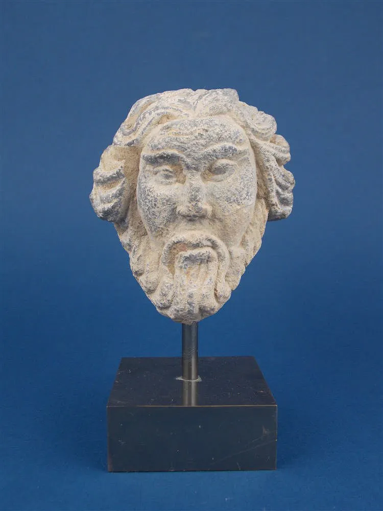 A bearded head of shale carved with metal base (Gandhara) from the fourth century AD, with a document of origin, from a former private collection in London, acquired around 1980.
