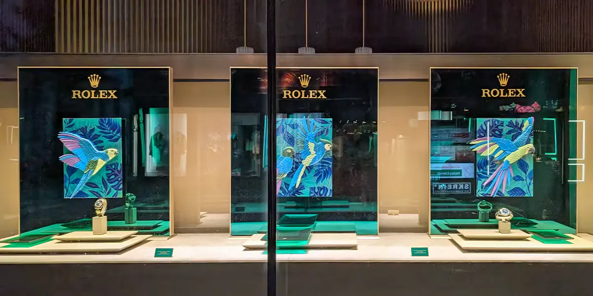 Le nom de la marque Rolex s'illumine le 8 juin 2025 au-dessus d'un salon de montres de luxe à Vienne, en Autriche. La vitrine d’une boutique présente des motifs animaliers. (Photo : Michael Nguyen/NurPhoto via Getty Images) (Détail)