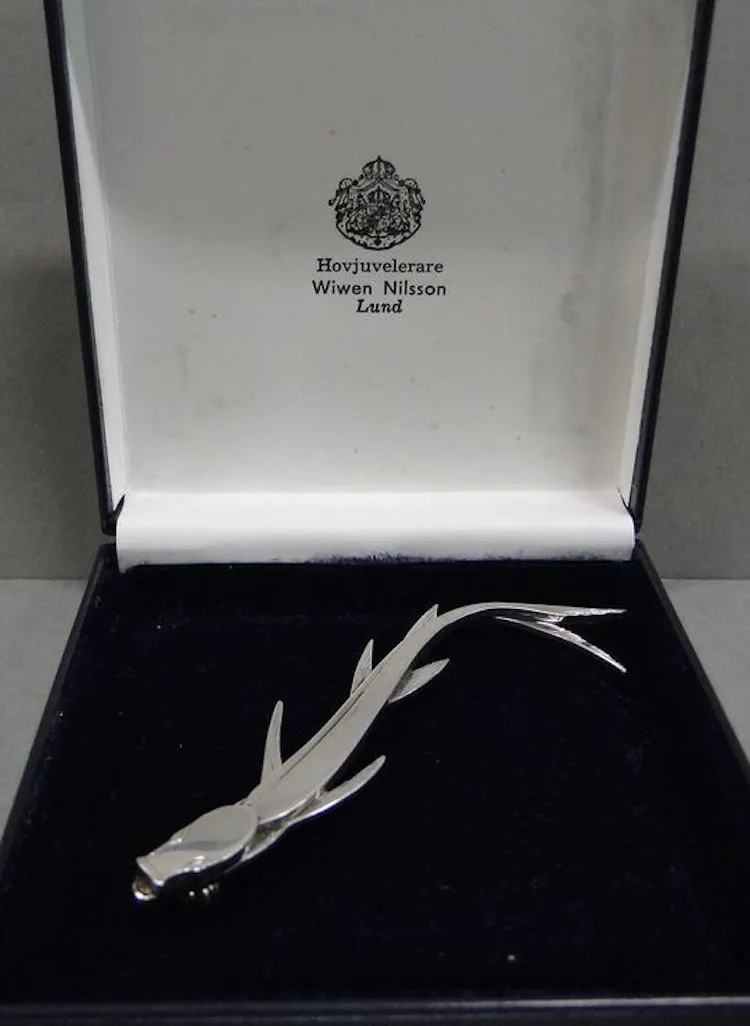Wiwen Nilsson, brosch i form av fisk nr. 70, silver 1958 AN Lund, L8,2cm, medföljande etui. Utrop: 3 000 SEK Björnssons Auktionskammare