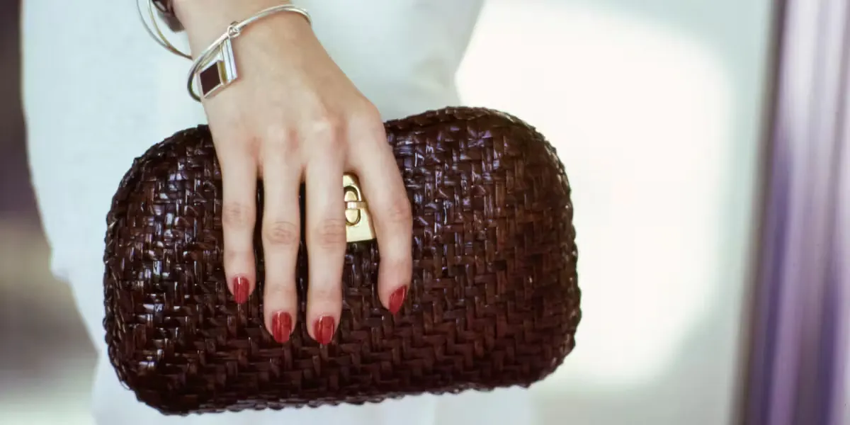 Vogue, April 1, 1974, close-up of a woman's hand holding a burgundy handbag made of thin, woven straw with gold fittings, from Rodo Handbags. Photo: Arthur Elgort/Conde Nast via Getty Images (detail).