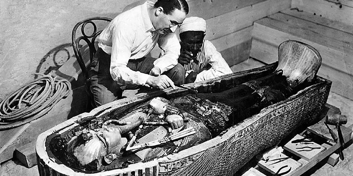 Howard Carter and a colleague examine the sarcophagus of Pharaoh Tutankhamun. Public domain photo (detail).
