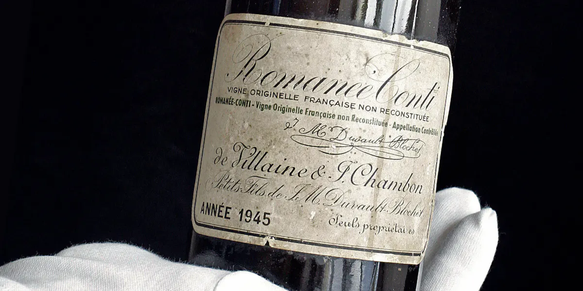 Ginevra, SVIZZERA: Immagine scattata l'11 maggio 2007 che mostra un dipendente di Christie's che espone una rara bottiglia di vino francese Romanee-Conti d'annata 1945 durante un'anteprima a Ginevra. Christie's ha annunciato il 15 maggio 2007 che la bottiglia è stata venduta per 35.000 euro tra diverse centinaia di lotti di grand crus durante una vendita di Christie's a sostegno della fondazione benefica "Children Action". Sono state prodotte solo 600 bottiglie di questo leggendario vino della Borgogna. PHOTO AFP / FABRICE COFFRINI (Photo credit should read FABRICE COFFRINI/AFP via Getty Images)