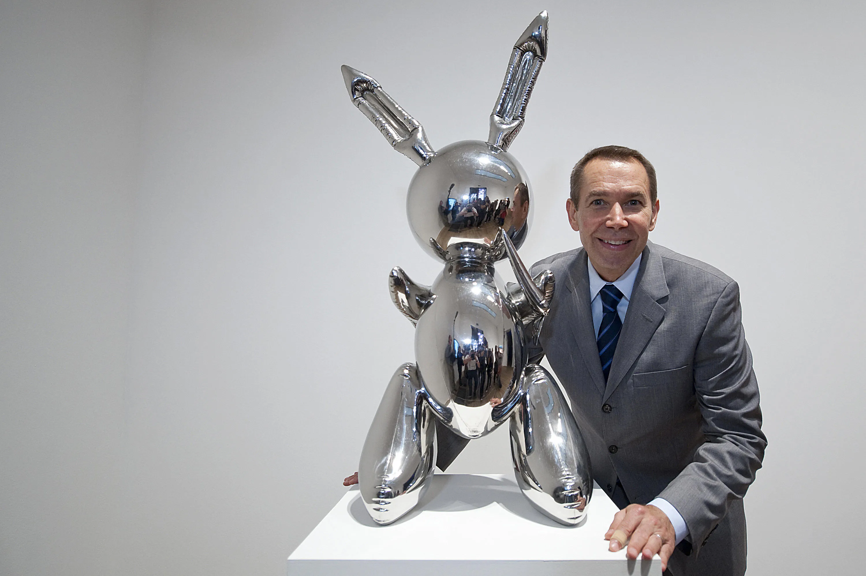 L'artista statunitense Jeff Koons posa per i fotografi con la sua opera d'arte intitolata 'Rabbit 1986' durante la rassegna stampa della mostra 'Pop Life, Art In A Material World' alla Tate Modern, a Londra, il 29 settembre 2009. Foto: BEN STANSALL/AFP via Getty Images