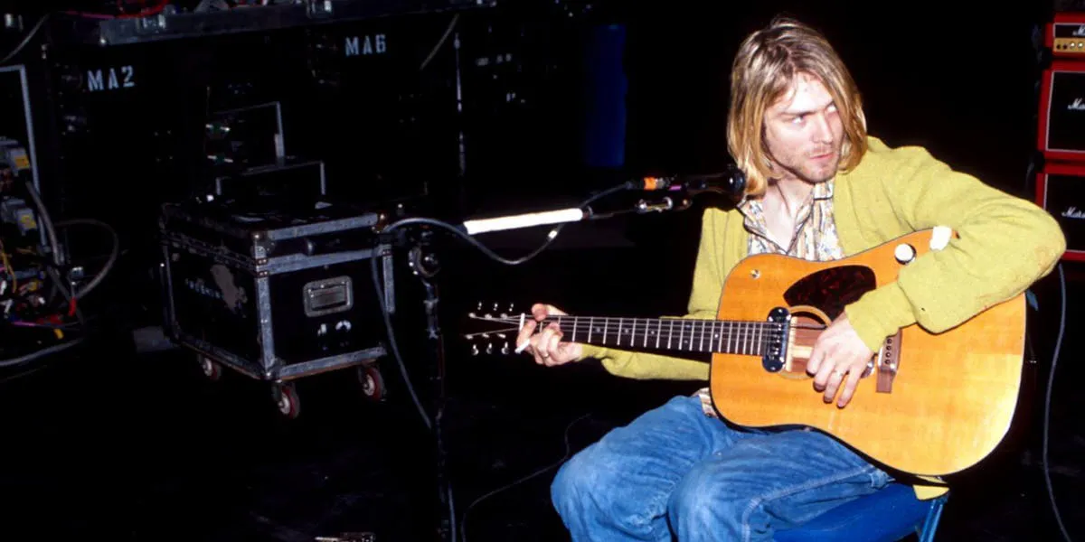 Kurt Cobain avec deux objets maintenant vendus aux enchères, son cardigan et l-sa guitare. Les deux ont été utilisés lors du concert  « MTV Unplugged » le 18 novembre 1993 à New York, image © Julien's Auctions