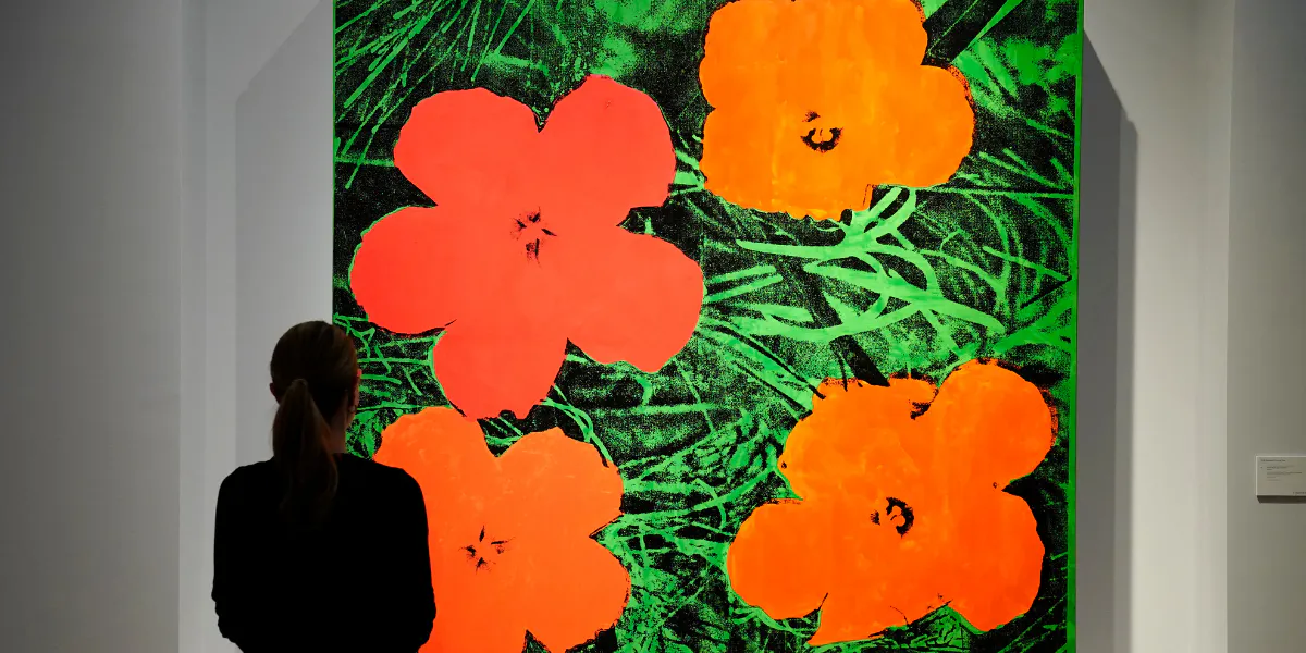 A person looks at US artist Andy Warhol's "Flowers" during a media preview at Christie's, ahead of their May 14 '21st Century Evening Sale', on May 3, 2024, in New York City. (Photo by TIMOTHY A. CLARY / AFP) (Photo by TIMOTHY A. CLARY/AFP via Getty Images) (detail)