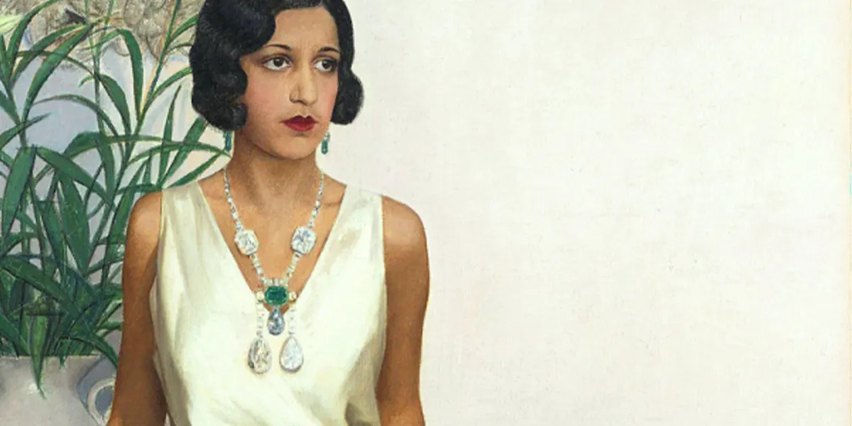 Maharani Sanyogitabai Devi di Indore, ritratta da Bernard Boutet de Monvel (1881–1949). La Maharani indossa una collana con varie pietre preziose, tra cui il Golconda Blue a forma di goccia. Foto di pubblico dominio (dettaglio)