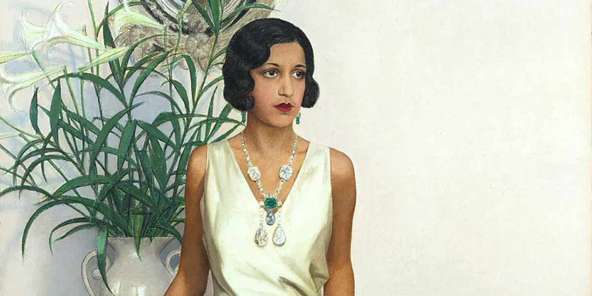 Maharani Sanyogitabai Devi d'Indore, portrait par Bernard Boutet de Monvel (1881-1949). La Maharani porte un collier dans lequel est serti, entre autres pierres précieuses, le « Golconda Blue  » en forme de poire. Photo dans le domaine public (détail)