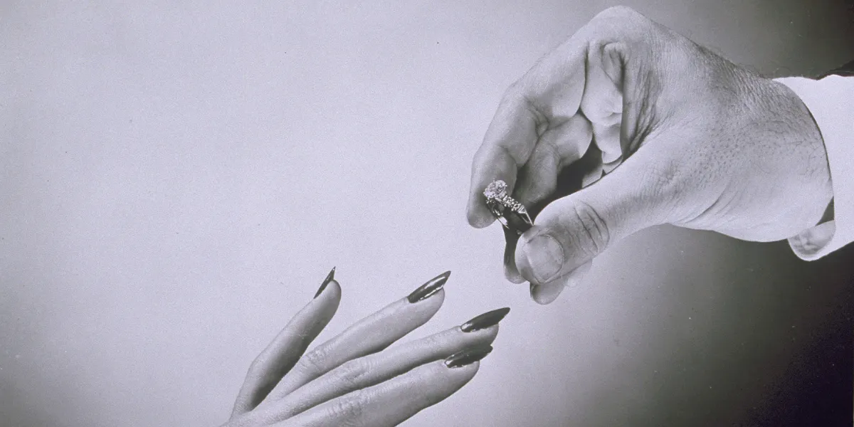 Hand receiving engagement ring. Photo © Getty Images