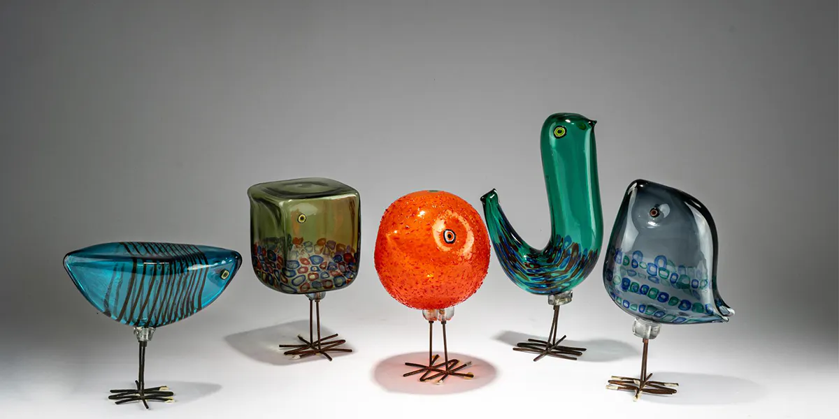 Alessandro Pianon, Fünf Vögel "Pulcino", 1961/62, vollständige Serie, Ausführung: Vetreria Vistosi, zwei Vögel mit Herstelleretikett, Überfangglas, farblos mit Unterfängen in Petrolgrün, Azurblau, Moosgrün, Graublau und Orange, Beine aus gehämmertem Kupferdraht, H. 17 - 29 cm. Foto © Quittenbaum Kunstauktionen (Detail)