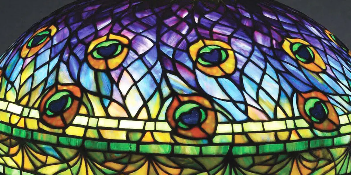 Lampe de table en verre plombé "Peacock" des studios Tiffany sur une rare base "Peacock" assortie. L'un des modèles de verre les plus appréciés et les plus emblématiques de Tiffany, présentant un motif de plumes de paon avec des "yeux" qui attirent l'attention. L'abat-jour et la base sont signés. Vendu au-dessus de l'estimation haute à 307 500 $. Avec l'aimable autorisation de Morphy Auctions
