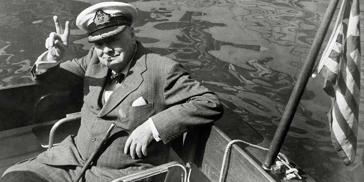 Storbritanniens före detta premiärminister Winston Churchill gör segertecknet while i hamnen Safi, Marocko. På väg till Aristotle Onassis yacht Christina (detalj). Foto: Getty Images