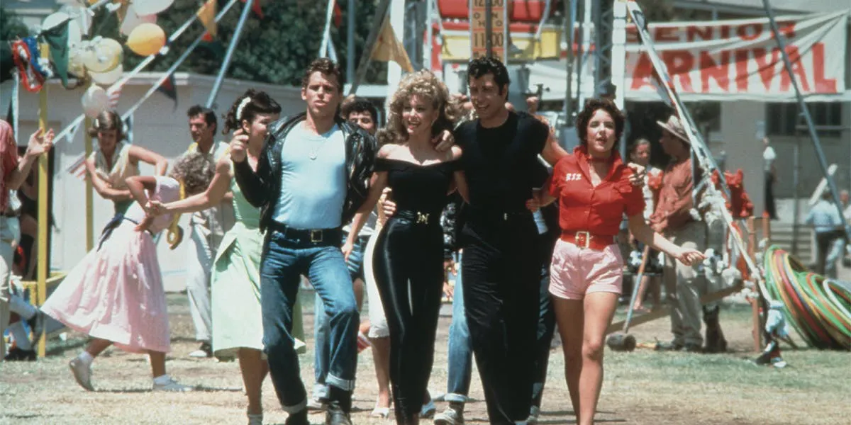De izquierda a derecha los actores: Jeff Conaway, Olivia Newton-John, John Travolta y Stockard Channing caminan juntos en un fotograma de la película Grease dirigida por Randal Kleiser (1978). Imagen: Paramount Pictures. Fotos International vía: Getty Images