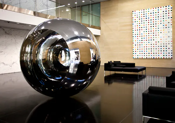 Au premier plan, une sculpture par Anish Kappor. Au fond, une toile par Damien Hirst 