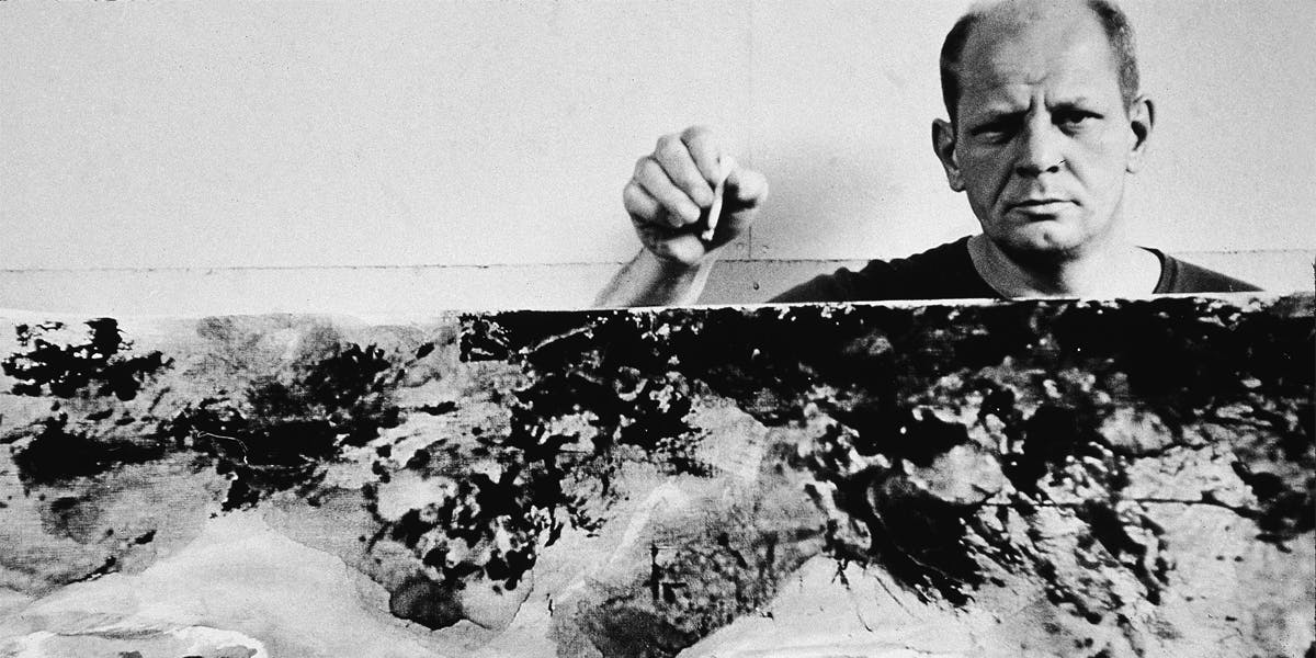 American abstract expressionist painter Jackson Pollock (1912 - 1956) holds a cigarette above and behind one of his paintings in his studio at 'The Springs,' East Hampton, New York, August 23, 1953 (detail). Photo by Tony Vaccaro/Getty Images
