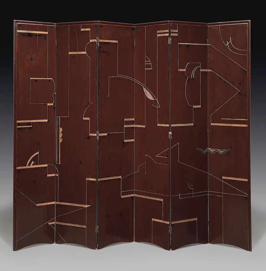 A varnished wooden folding screen, designed by Eileen Gray around 1922-25. The screen is characteristic of the lacquer works displayed in her shop Jean Désert. Photo © Christie's
