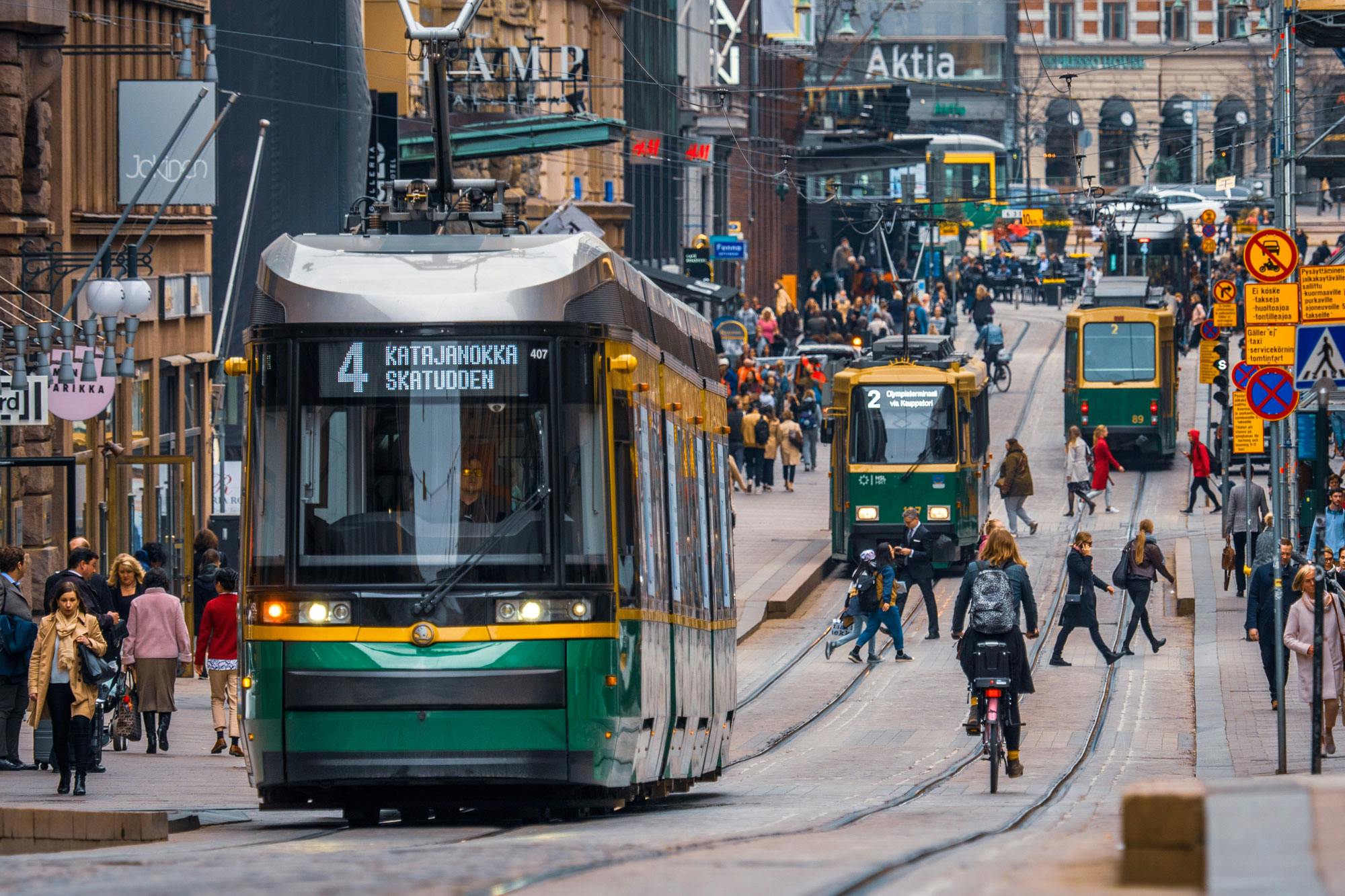 People and trams on a street in Helsinki.